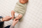 Mom wrapping newborn in LullaBaby Swaddle - Desert Sage